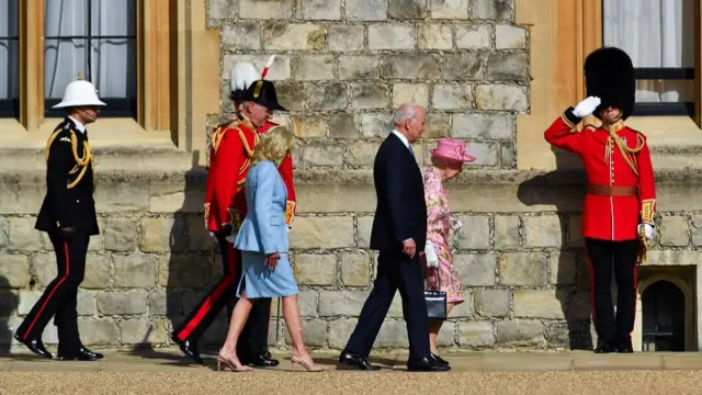 U.S. President Joe Biden and first lady Jill Biden walk next to Britain"s Queen Elizabeth, at Windsor Castle in Windsor, Britain