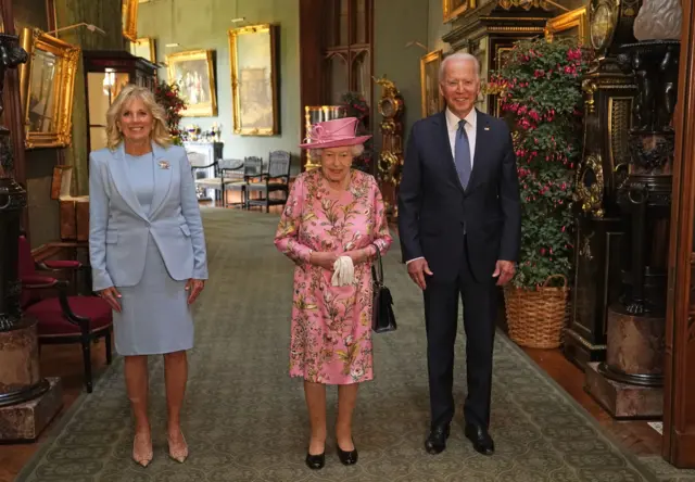 Queen Elizabeth II (centre) with US President Joe Biden and First Lady Jill Biden in the Grand Corridor during their visit to Windsor Castle in Berkshire