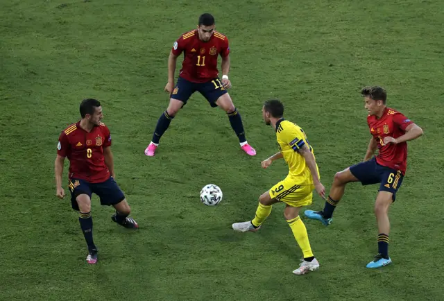 Three Spain players surround a Sweden player