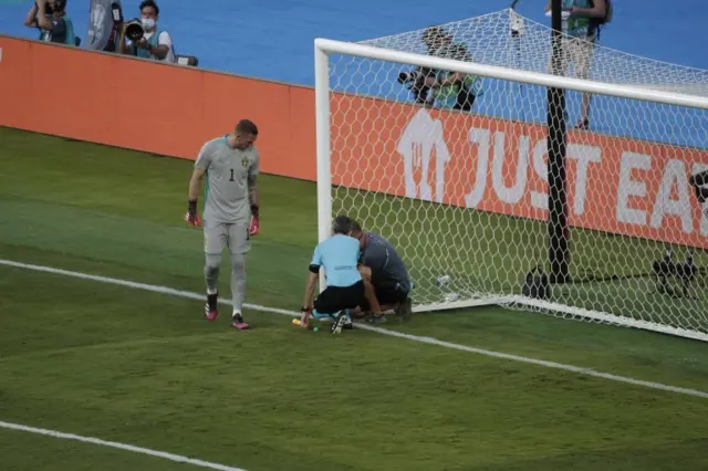 Officials fix a problem with the goal net before kick-off