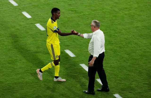 Alexander Isak shakes hands with coach Jan Andersson as he comes off