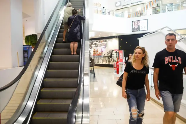 People visit Dizengoff shopping centre as Israel ends one of its last main restrictions of mask wearing in indoor spaces