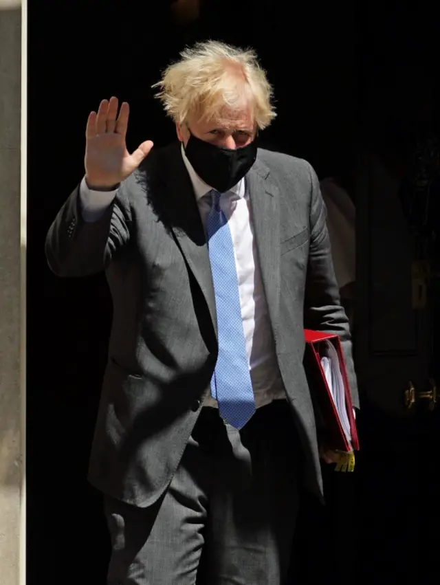 Prime Minister Boris Johnson waves to the cameras as he leaves Downing Street to attend Prime Ministers Questions