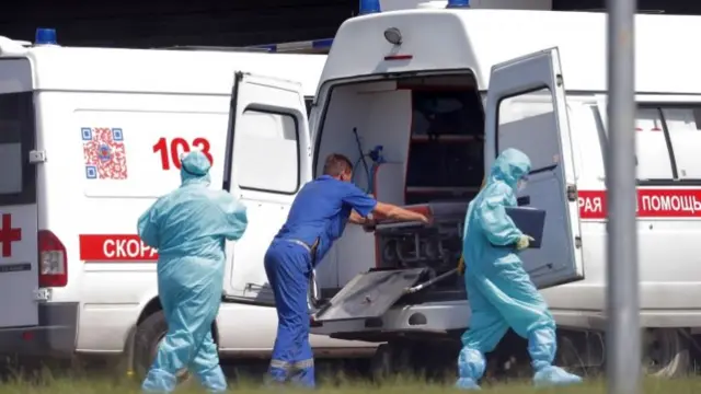 Health workers wearing protective equipment wait for Covid-19 patients at the hospital complex in the Kommunarka settlement in Moscow, Russia, 14 June 2021