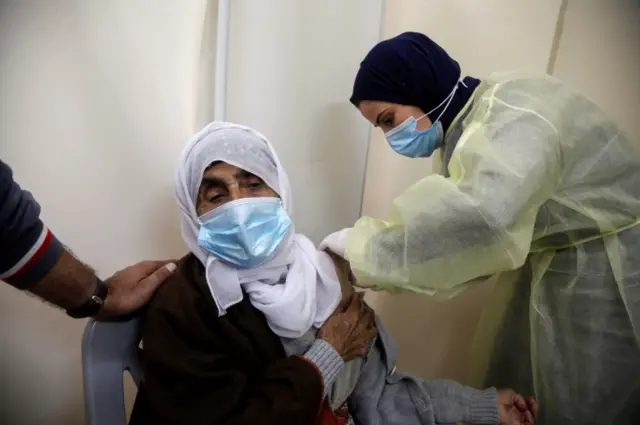 File picture of a woman getting a vaccine against Covid during a vaccination drive in Tubas, in the Israeli-occupied West Bank in March 2021