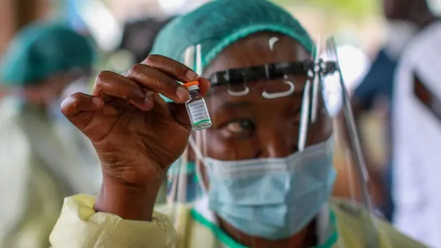A health worker holds a vaccine
