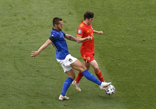 Italy's Rafael Toloi and Wales' Daniel James battle for the ball