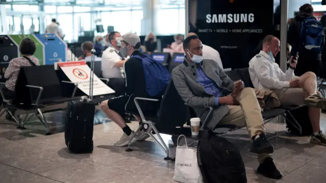 Passengers wait at the Terminal 5 departures area at Heathrow Airport in London, Britain,