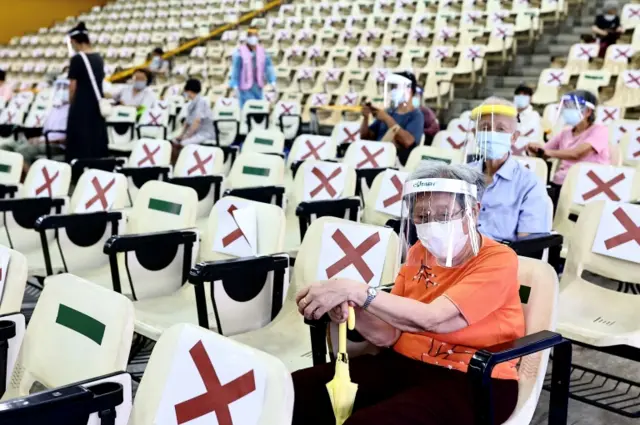 People wait at the observation area after receiving the vaccine against the coronavirus disease (COVID-19), during a vaccination session for elderly people over 85 years old, at an auditorium in New Taipei City, Taiwan