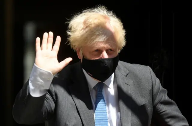 Boris Johnson waves to the press as he leaves No 10 Downing Street for prime minister's questions in the Commons