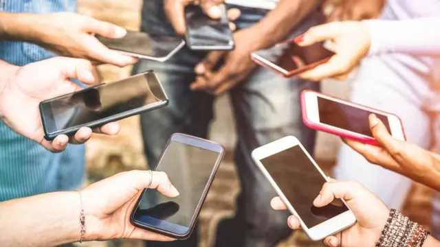 Stock image of people holding mobile phones