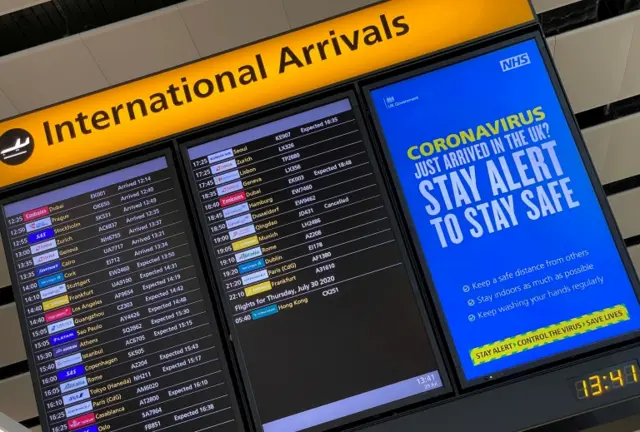 Airport arrivals board with coronavirus information