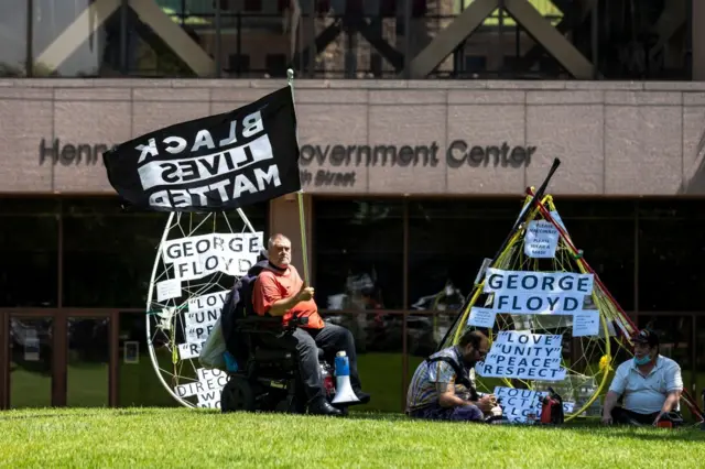 There are small protests outside the courthouse, but fewer of the security measures seen during the highly-charged trial