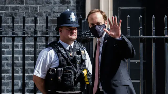 Matt Hancock walks past a police officer outside Downing Street