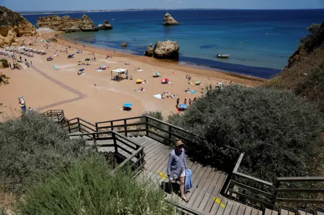 A person leaves Dona Ana beach in Lagos, Portugal, on 3 June 2021