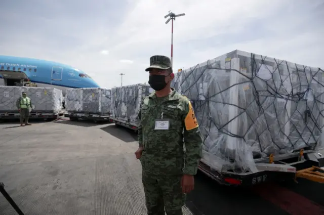 A member of the National Guard looks on as a batch of AstraZeneca Covid-19 vaccines, delivered under the Covax scheme, is unloaded in Mexico City, Mexico, on 27 May 2021