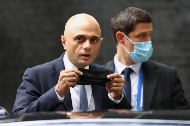 Health Secretary Sajid Javid puts on a face mask, as he left Downing Street earlier