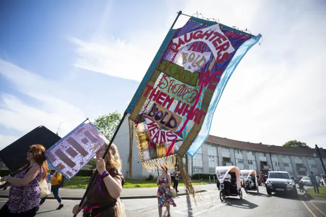 A banner reading: 'Our daughters are bold because we showed them what bold means'