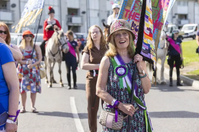 Modern day Godivas selected by public nomination ride on horseback from various wards of the city accompanied by women bearing banners and flags representing their manifesto for the city