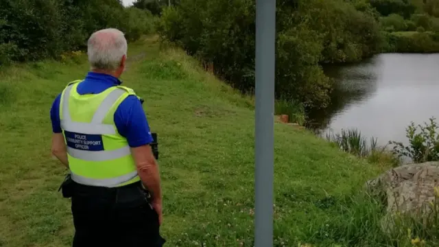 A police community support officer on patrol in park in Kidsgrove