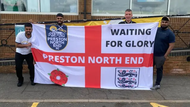 Mohammed Patel and his friends with an England flag at Watford Gap services