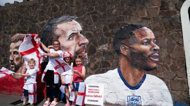 Fans gather by a new mural in Nuneaton by artist Nathan Parker, depicting Gareth Southgate, Harry Kane and Raheem Sterling