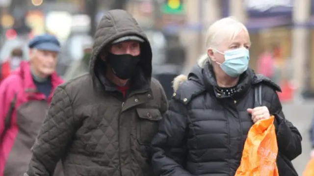 Two people wearing a mask