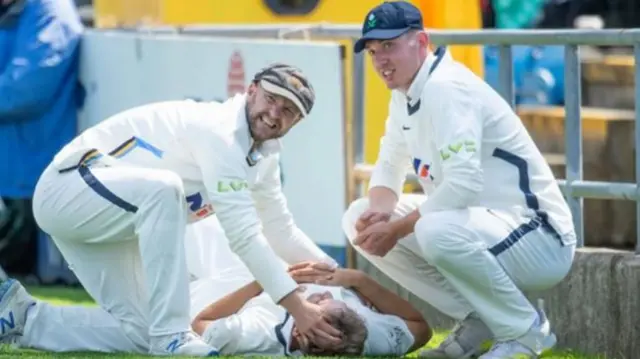 Adam Lyth and George Hill comforted their Yorkshire team-mate Dom Leech after his injury at Emerald Headingley