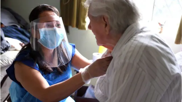 A care home staff member with a resident