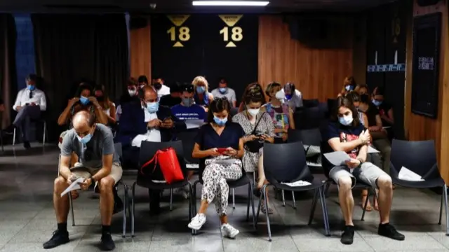 Young people in Madrid sit after receiving vaccine