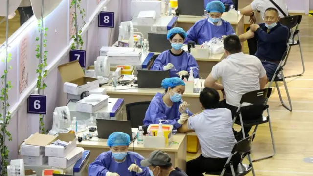 This photo taken on July 5, 2021 shows people receiving the China National Biotec Group (CNBG) Covid-19 coronavirus vaccine in Nantong, in China's eastern Jiangsu province