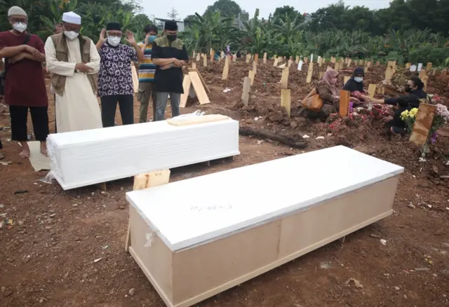 Funeral prayer at coffin on outskirts of Jakarta