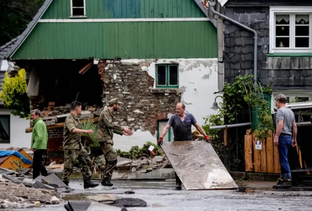 German Army soldiers and local residents are seen after flooding in Hagen, Germany