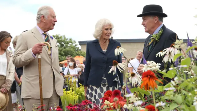 Prince Charles and Camilla speak to a man