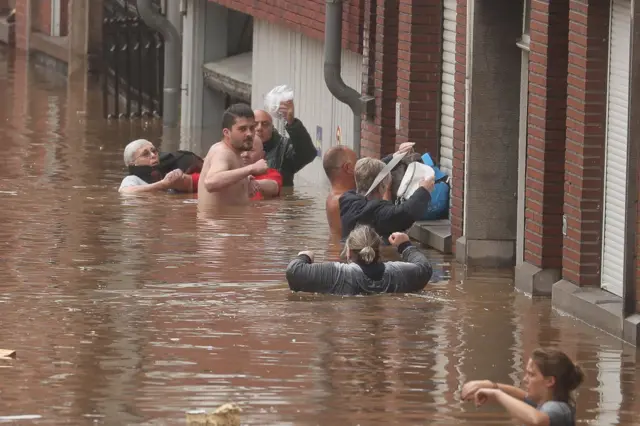 People wade through water in Liege