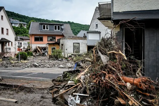 Damaged houses and piles of  trees are pictured in town of Schuld