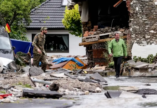 A German Army soldier and local resident are seen after flooding in Hagen