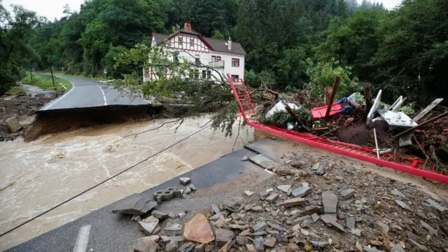 Flood water sweeps part of a road away in Schuld, Germany