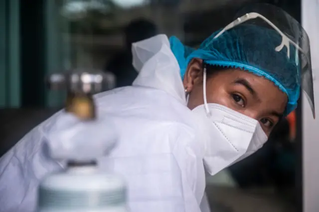 Hunsa Jaicheun (30), a recovered COVID-19 patient turned volunteer for the response team of Zendai, reacts to the camera on July 16, 2021 in Bangkok