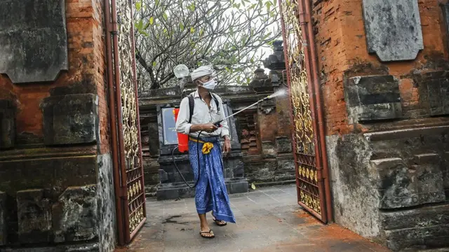 A man disinfects a wall