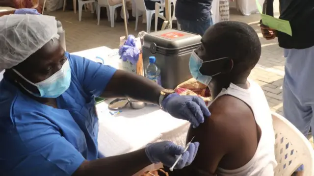 People receive a dose of the Oxford AstraZeneca coronavirus vaccine in Nigeria