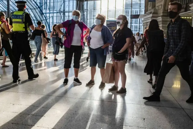 People wearing masks at a train station