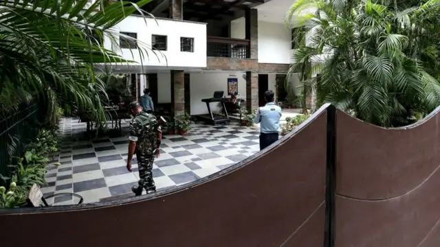 Security personnel stand guard at the residence of Sudhir Agrawal, Managing Director of the Hindi-language Dainik Bhaskar daily newspaper which was raided by Indian tax authorities