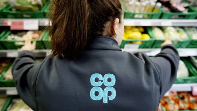 A Co-Op supermarket worker with her back to the camera