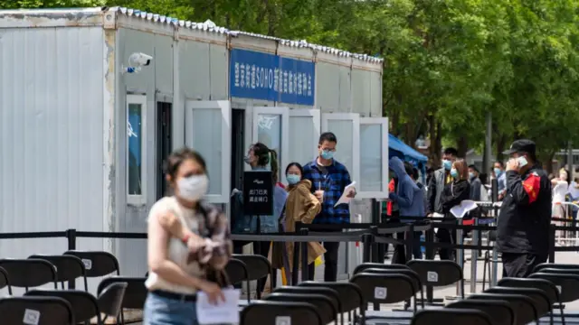 People line up to receive a dose of the COVID-19 vaccine at a square in Beijing