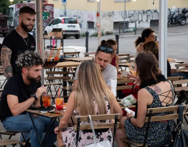 People gather at outdoor restaurant in June in Rome