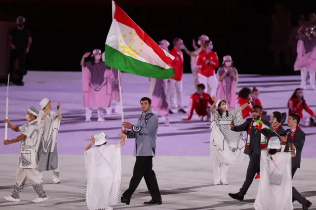 Flag bearer Temur Rakhimov of Team Tajikistan