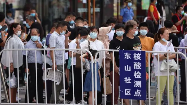 People line up at a makeshift nucleic acid testing site outside a shopping mall in Jiangning district, following new cases of the coronavirus disease (COVID-19) in Nanjing, Jiangsu province, China