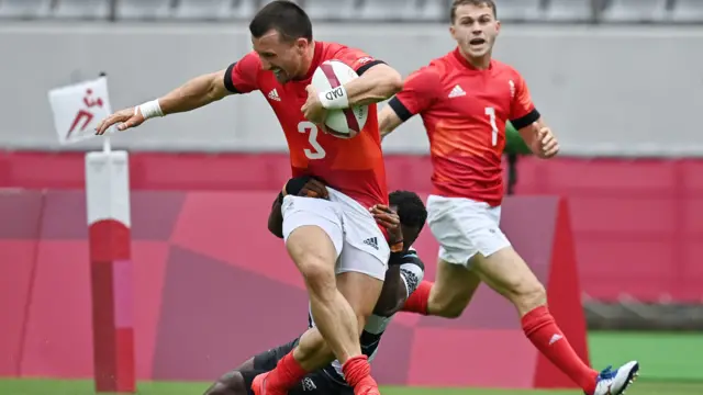 Britain's Alex Davis (L) is tackled by Fiji's Jerry Tuwai.