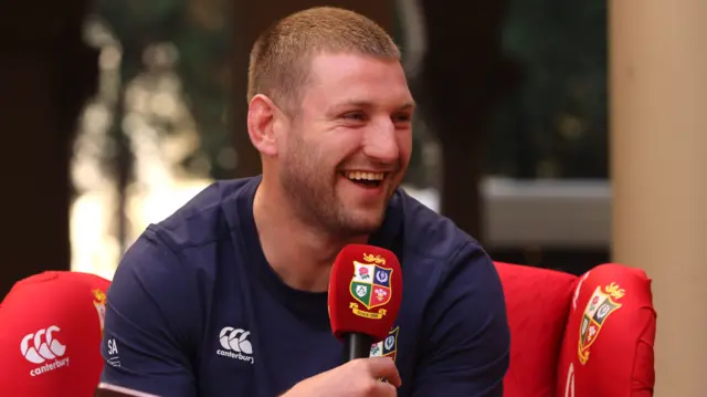 Finn Russell laughs into a microphone